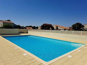 a blue swimming pool on top of a house at Piscine commune, terrasse, maison pour 5 in Saint-Vincent-sur-Jard