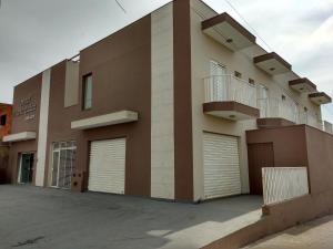 um edifício com duas portas de garagem e duas varandas em Hotel Maria Luiza em Jundiaí