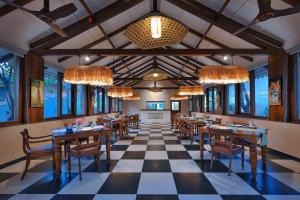 a restaurant with tables and chairs on a checkered floor at MeruVann, Kanha National Park in Bhimlath