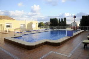 a large swimming pool with lounge chairs around it at La Estancia del Rincon in Cabo de Palos