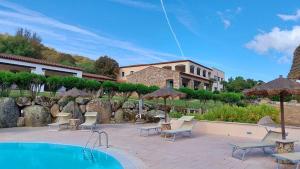 a resort with a swimming pool in front of a building at Hotel Valkarana Country Relais in Sant Antonio Di Gallura