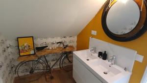a bathroom with a bicycle and a mirror and a sink at la bicyclette rouge by les étapes chartraines in Chartres