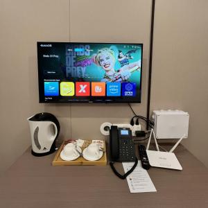 a desk with a tv and a phone and a phone at Sky Vista Hotel in San Jose