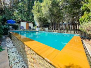 a large swimming pool with a yellow and blue at Private Pool Villa , 4BR, Fast WiFi, BBQ Garden in Ban Dan Mai