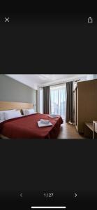 a hotel room with a red bed and a window at Novelrooms in Paralia Katerinis