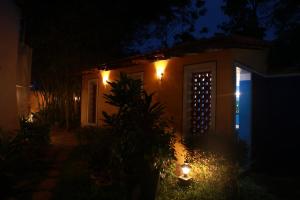 una casa con la puerta iluminada por la noche en Vox Sippi, en Kuilapayam
