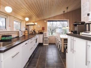 eine große Küche mit weißen Schränken und einem Tisch in der Unterkunft 6 person holiday home in Slagelse in Slagelse + 21 Fotos