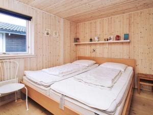 ein Bett in einem Zimmer mit einer Holzwand in der Unterkunft 6 person holiday home in Slagelse in Slagelse