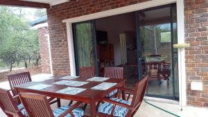 a wooden table and chairs on a patio at Vachellia View in Marloth Park
