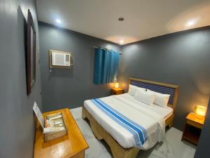 a bedroom with a large bed and a table at Angkel's Place in Bangued