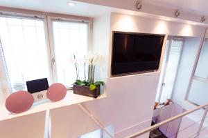 uma sala de estar com uma televisão de ecrã plano na parede em Stylish,luxury duplex Paris city center em Paris