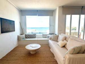 a living room with a couch and a table at Apartamento Poblado marinero in Arenal d'en Castell