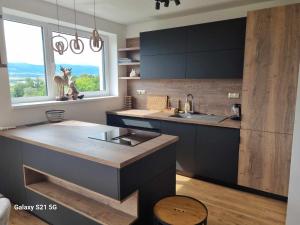 a kitchen with black cabinets and a sink and a window at PENTHOUSE BUTTERFLY - Bojnice in Bojnice