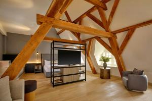 a living room with a television and a bed at Ghent Marriott Hotel in Ghent