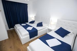 two beds in a room with blue and white at Hotel Elior in Tirana