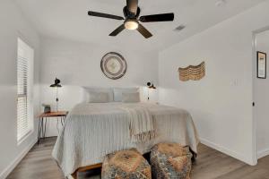 a bedroom with a bed with a ceiling fan at Wanderlust #4 | Hot Tub | Shared Outdoor Space in Fredericksburg