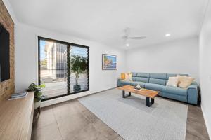 Una sala de estar con un sofá azul y una mesa. en Little Mountain Modern Acreage Retreat, en Caloundra West 34 fotos más