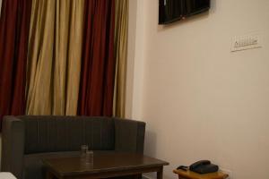 a room with a couch and a table and curtains at Hotel Krishna in Jaipur +23 photos