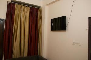 a room with a curtain and a television on a wall at Hotel Krishna in Jaipur