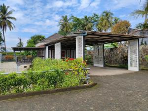 a small house with awning and flowers at Guest House Shakilla 2 Rancagoong Syariah in Tjiandjur