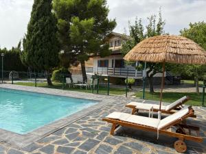 a chair and umbrella next to a swimming pool at Villa Independiente con Bodega y Barbacoa - perfecto familia y grupos in Alacón