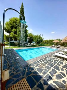 una gran piscina con una fuente de agua en VlLLA PRIVADA - CASA DE MADERA, en Alacón