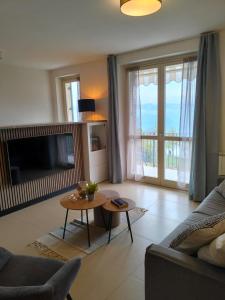 a living room with a couch and a table at Balconi sul Lago - Stunning Lakeview and Pool in Parzanica