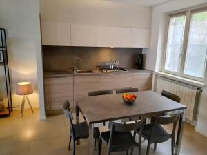 a kitchen with a table with chairs and a sink at Balconi sul Lago - Stunning Lakeview and Pool in Parzanica