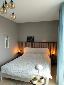 a bedroom with a white bed with a wooden headboard at Balconi sul Lago - Stunning Lakeview and Pool in Parzanica +32 photos