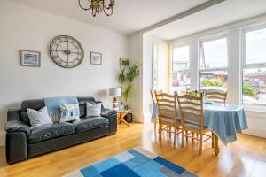 a living room with a table and a couch at Bay View Apartment in Hunstanton