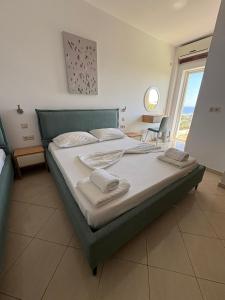 ein Schlafzimmer mit einem Bett, auf dem zwei Handtücher liegen in der Unterkunft Hotel Afrodite in Dhërmi