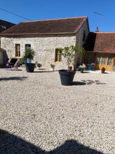 a stone house with potted plants in front of it at Gite Simon in Guillon