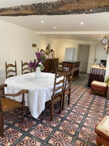 a dining room with a table with a vase of flowers on it at Gite Simon in Guillon