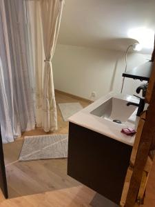 a bathroom with a sink and a window with curtains at Gite Simon in Guillon