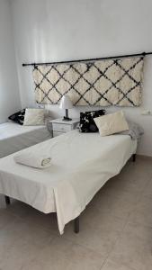 two beds in a hotel room with at Primera línea en Denia in Denia
