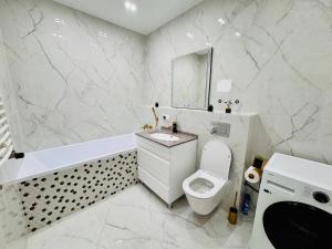een witte badkamer met een toilet en een wastafel bij Royal Boulevard Terrace Residence in Chişinău +16 foto's