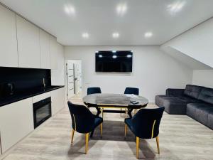 a living room with a table and chairs and a couch at Royal Boulevard Terrace Residence in Chişinău
