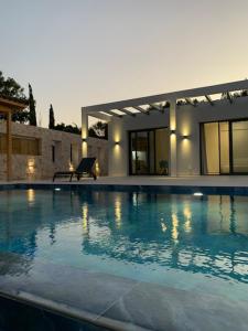 a large swimming pool in front of a house at Profil villas in Spartià