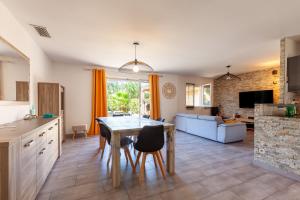 レ・ペンヌ・ミラボーにあるMaison Tout Confortのテーブルと椅子のあるキッチンとリビングルーム