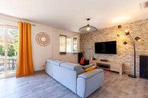 レ・ペンヌ・ミラボーにあるMaison Tout Confortの青いソファとテレビのあるリビングルーム