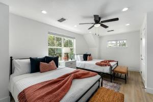Un dormitorio con dos camas y un ventilador de techo. en Rosé Retreat: Luxurious Getaway for 6, Hot Tub, Steps to Main Street, en Fredericksburg