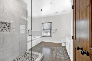 Un baño con ducha de cristal y un inodoro. en Schubert Inn Cottage - Pool - Walk to Main St, en Fredericksburg 11 fotos más