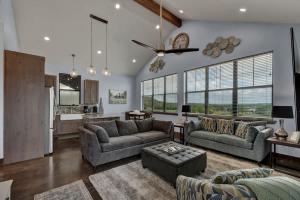a living room with two couches and a kitchen at West End Luxury Retreat with Resort Style Pool and Hot Tub! in Fredericksburg