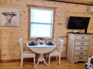 フレデリックスバーグにあるStunning Cabin Right on Main St!のテーブルと椅子とテレビのあるダイニングルーム