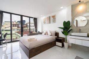 a bedroom with a large bed and a sink at Ekomo Home 95 - Metro Ben Thanh in Ho Chi Minh City +85 photos