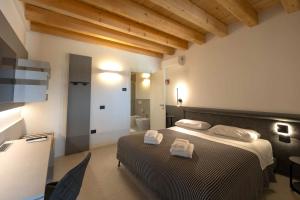 a bedroom with a bed with two towels on it at Alma Room in Colceresa +2 photos