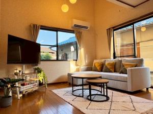 a living room with a couch and a table at OKA Stay OKAYAMA in Okayama