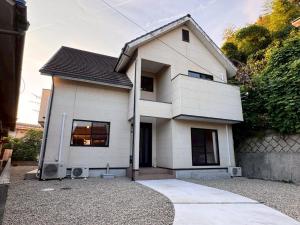 a white house sitting on top of a driveway at OKA Stay OKAYAMA in Okayama