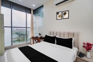 a bedroom with a large bed and a large window at Super Townhouse Sector 63 A Noida in Noida