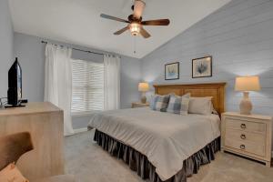 Un dormitorio con una cama y un ventilador de techo. en Fisherman Friend! - Coastal Condo - Views Await!, en Fulton